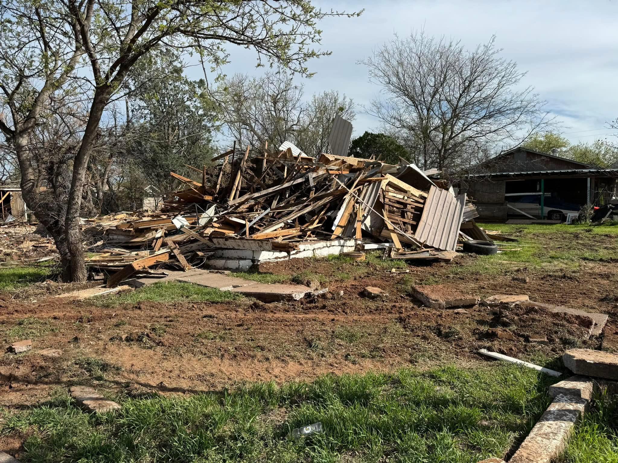 Demolished wood structure gathered on a cleared residential site