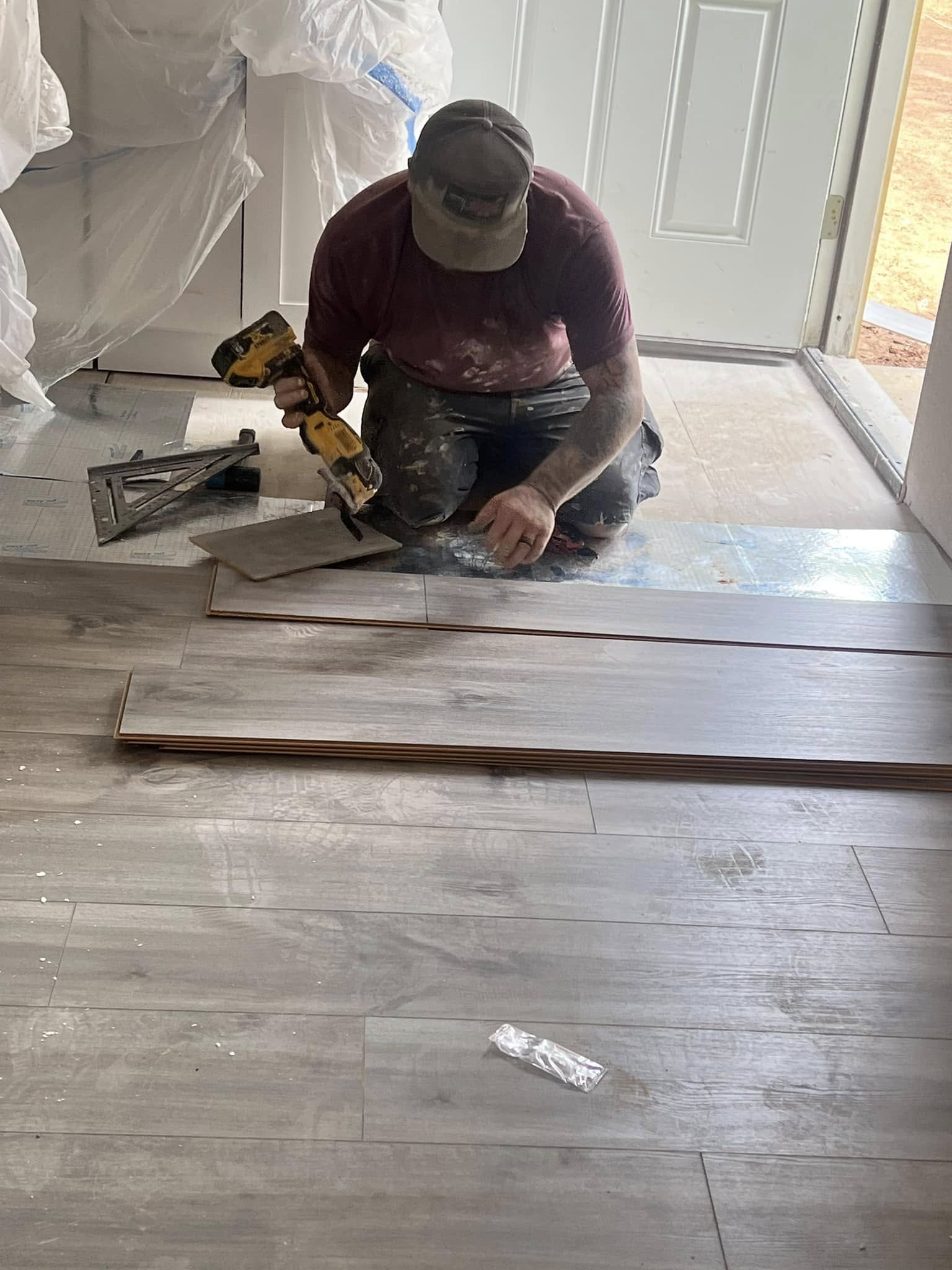 Bin Bros crew member cutting a flooring board