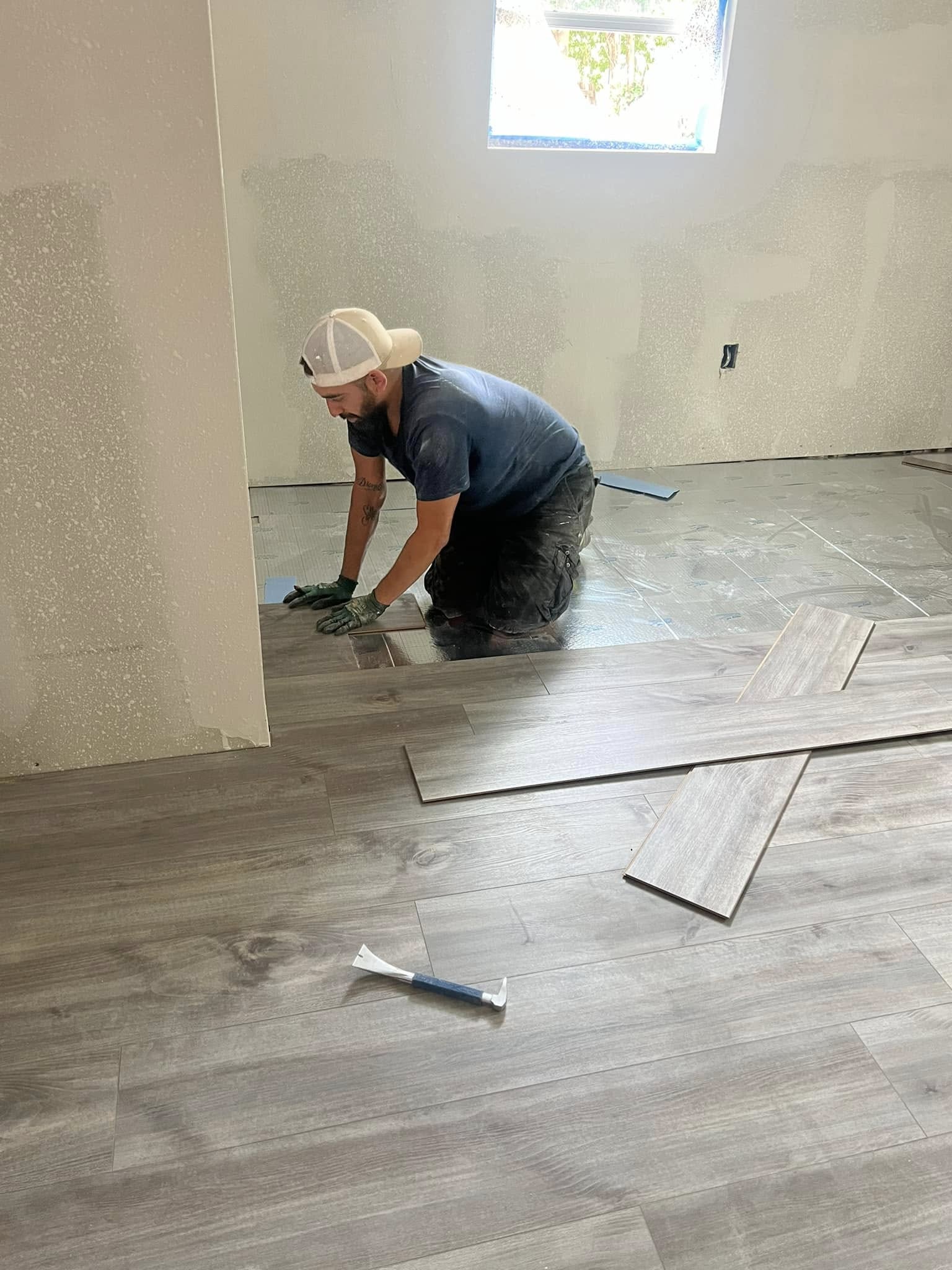 Bin Bros crew member installing flooring in an unfinished room