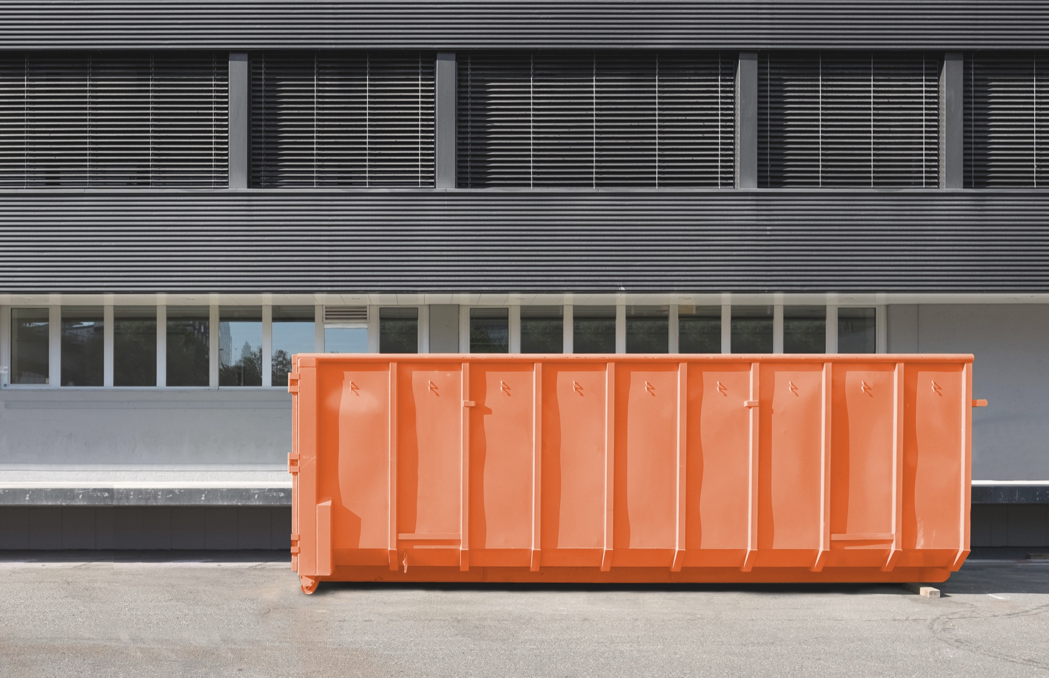 Orange roll-off dumpster at a property