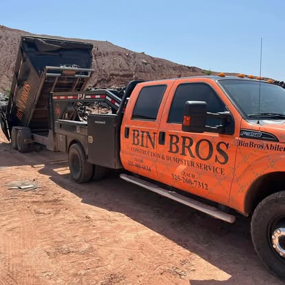 Bin Bros truck delivering a roll-off dumpster